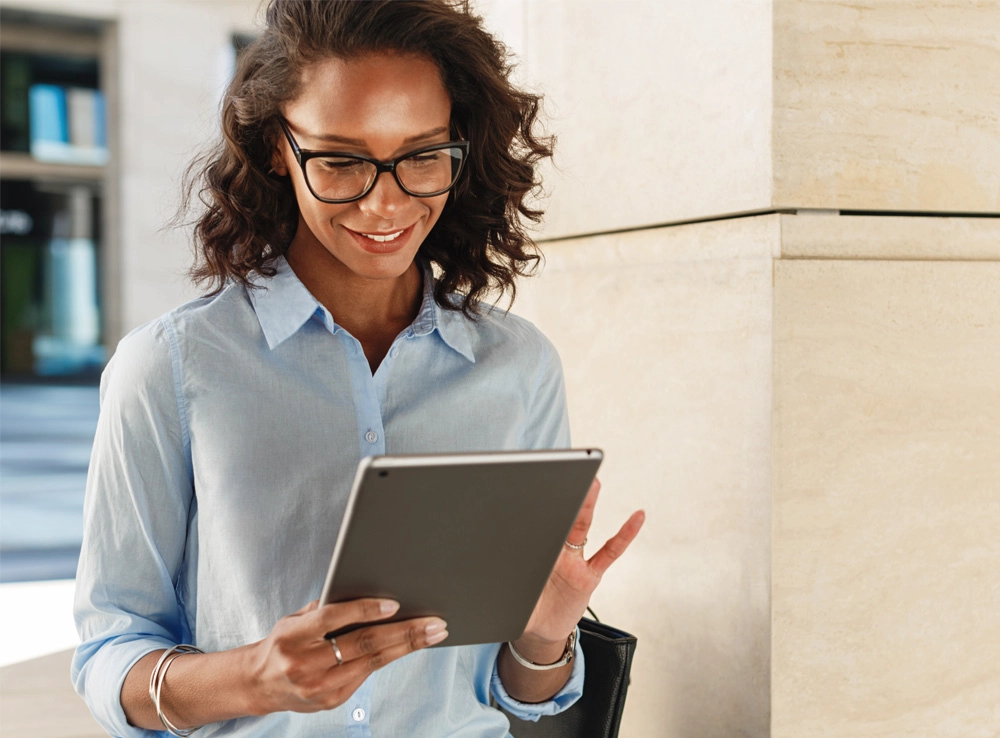 A teacher looking at Galeria's online assesment solutions on a tablet.