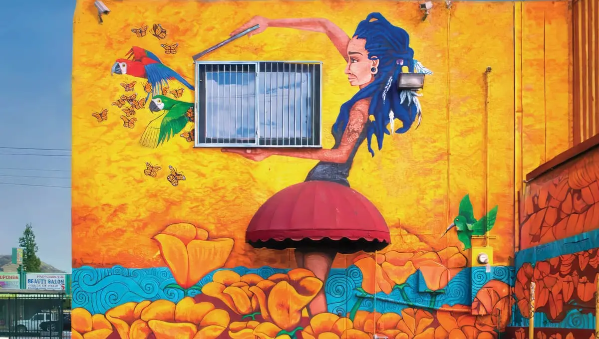 A mural of a girl holding a cage, letting a bird and butterflies out