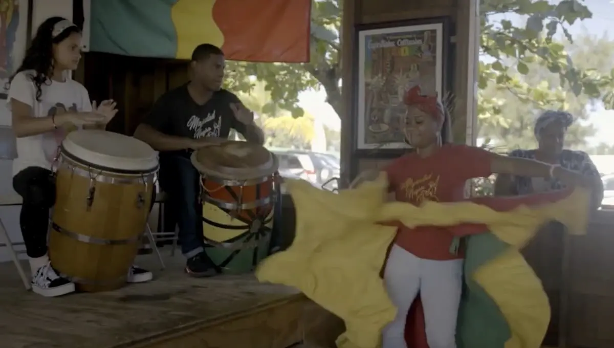 People playing the drums and dancing.