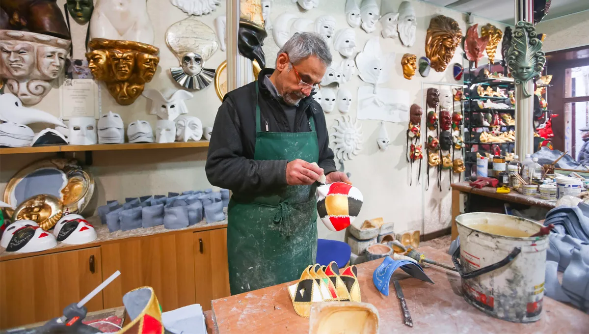 A man making masks in a workshop.