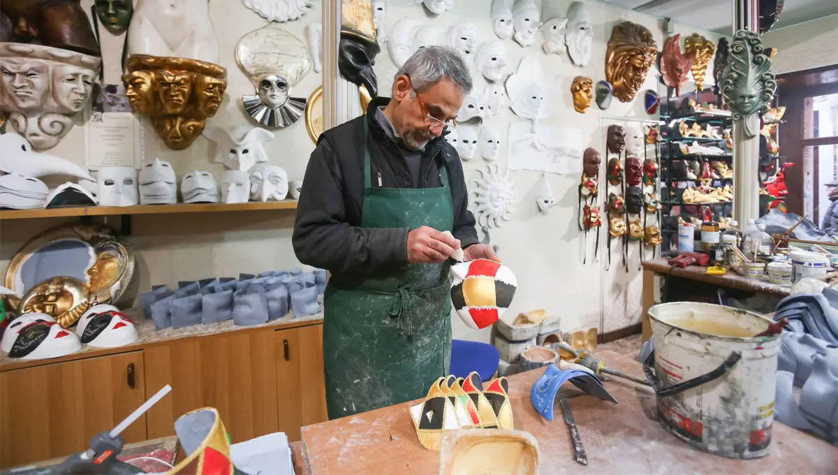 A man making masks in a workshop.