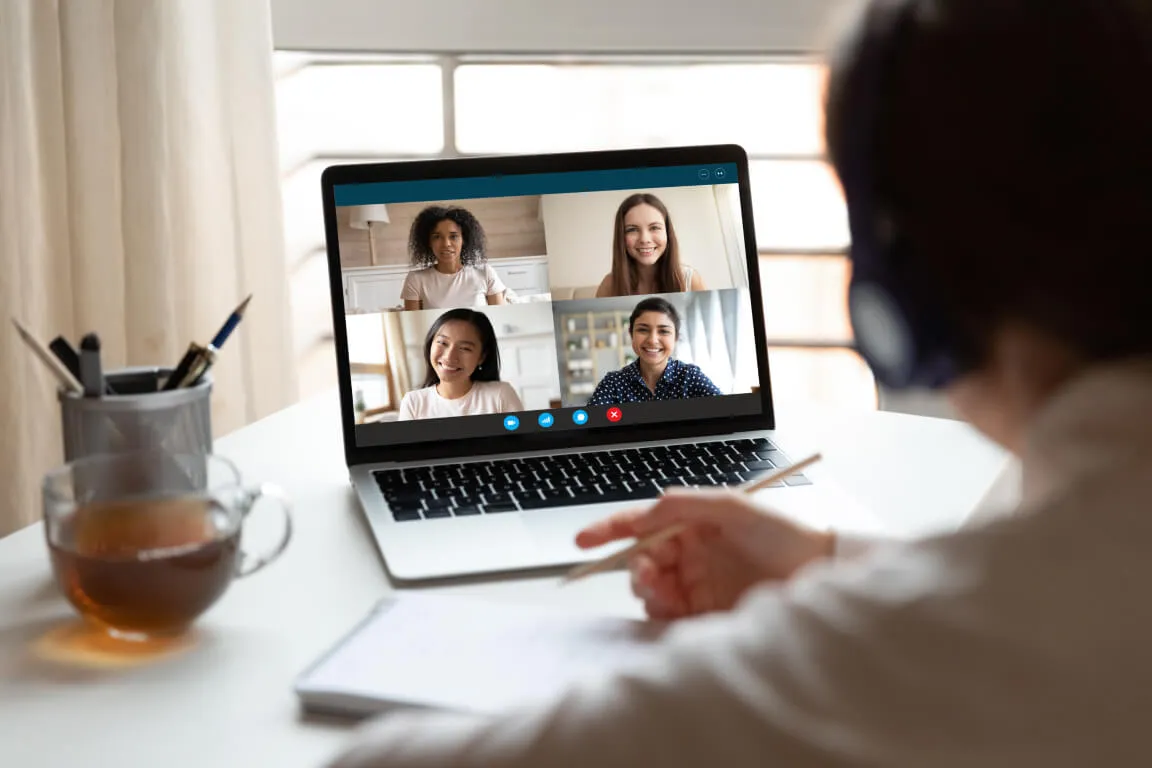 A student doing a group video call with other students on a laptop