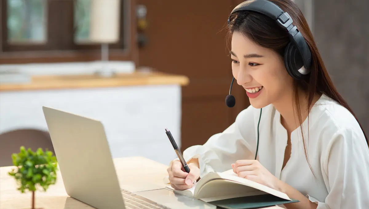 A support agent answering a call while looking at a laptop.