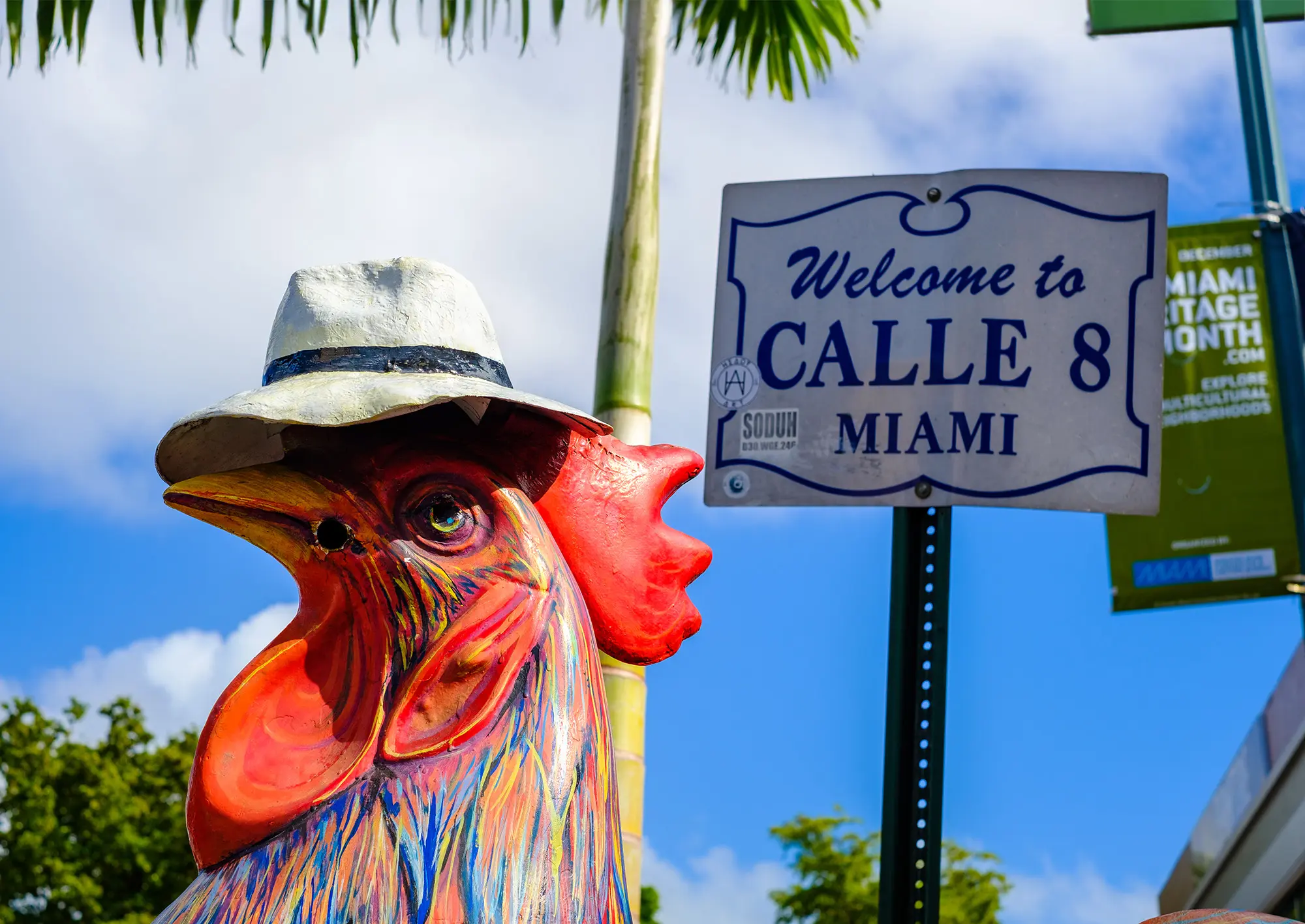 A street sign with a rooster in front of it