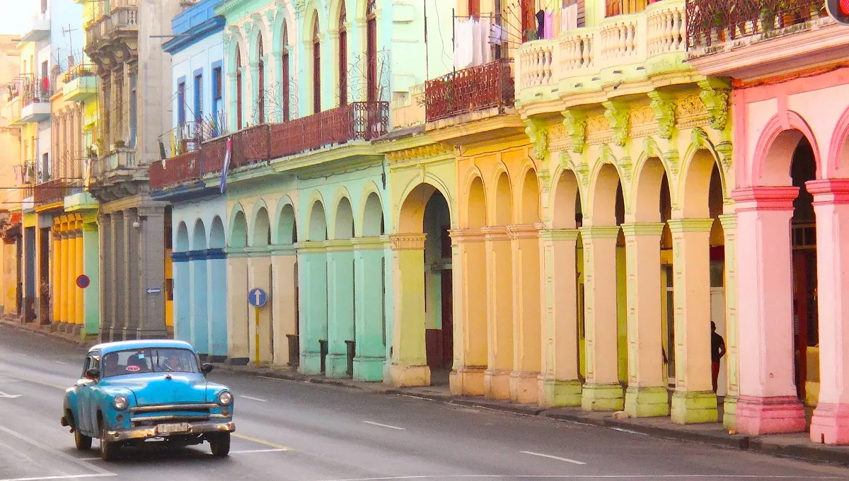 A car drivinng on a colorfull street in Spain.